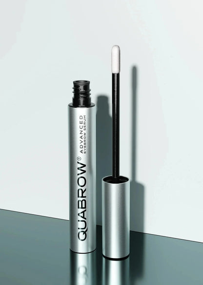 QUABROW Advanced Eyebrow Serum standing upright with the applicator opened on a reflective surface
