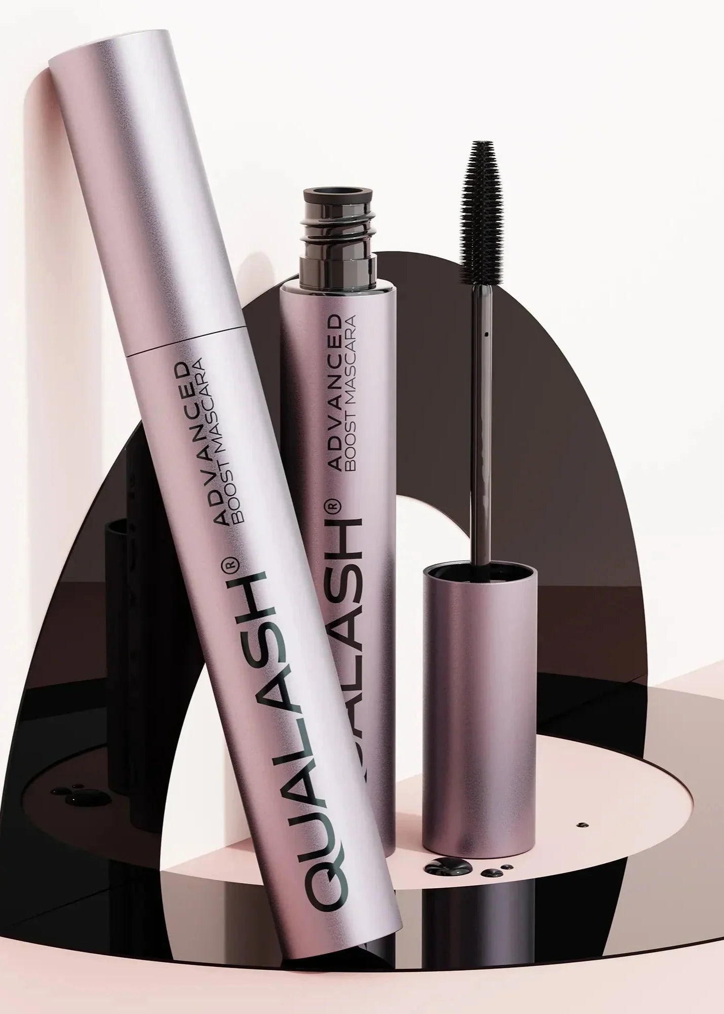 QUALASH Advanced Boost Mascara set displayed on modern artistic black and pink setup
